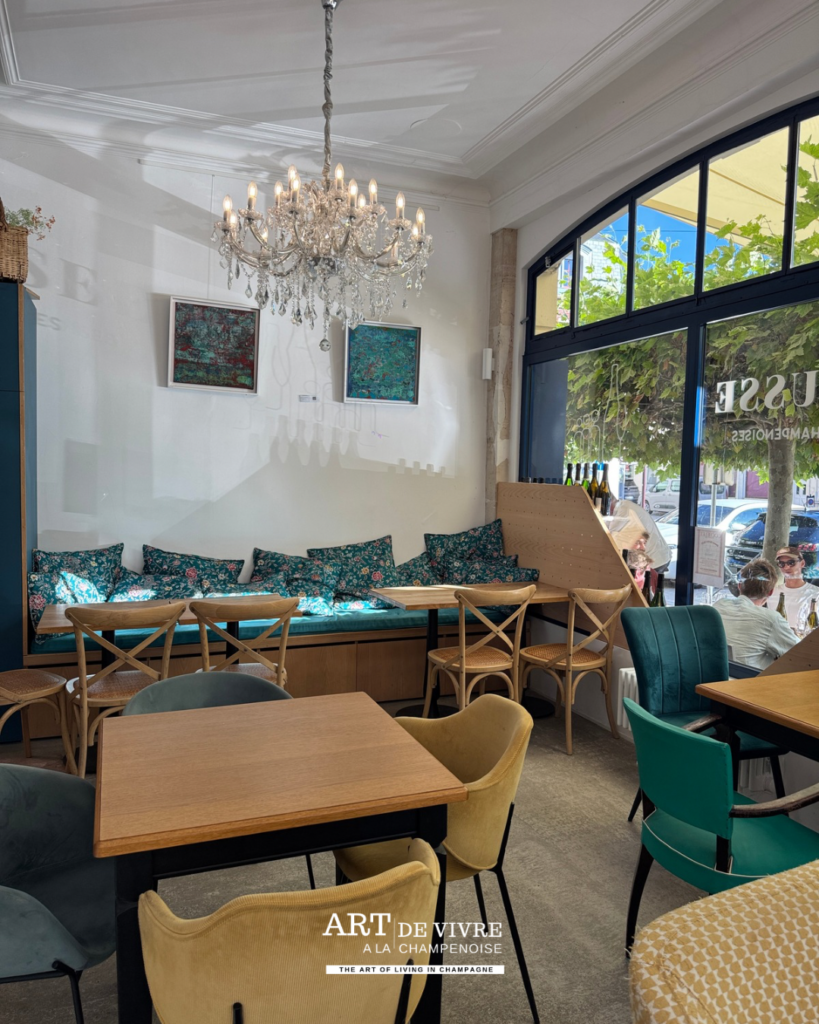 Intérieur de La Frigousse à Aÿ-Champagne avec fauteuils, canapé et tables